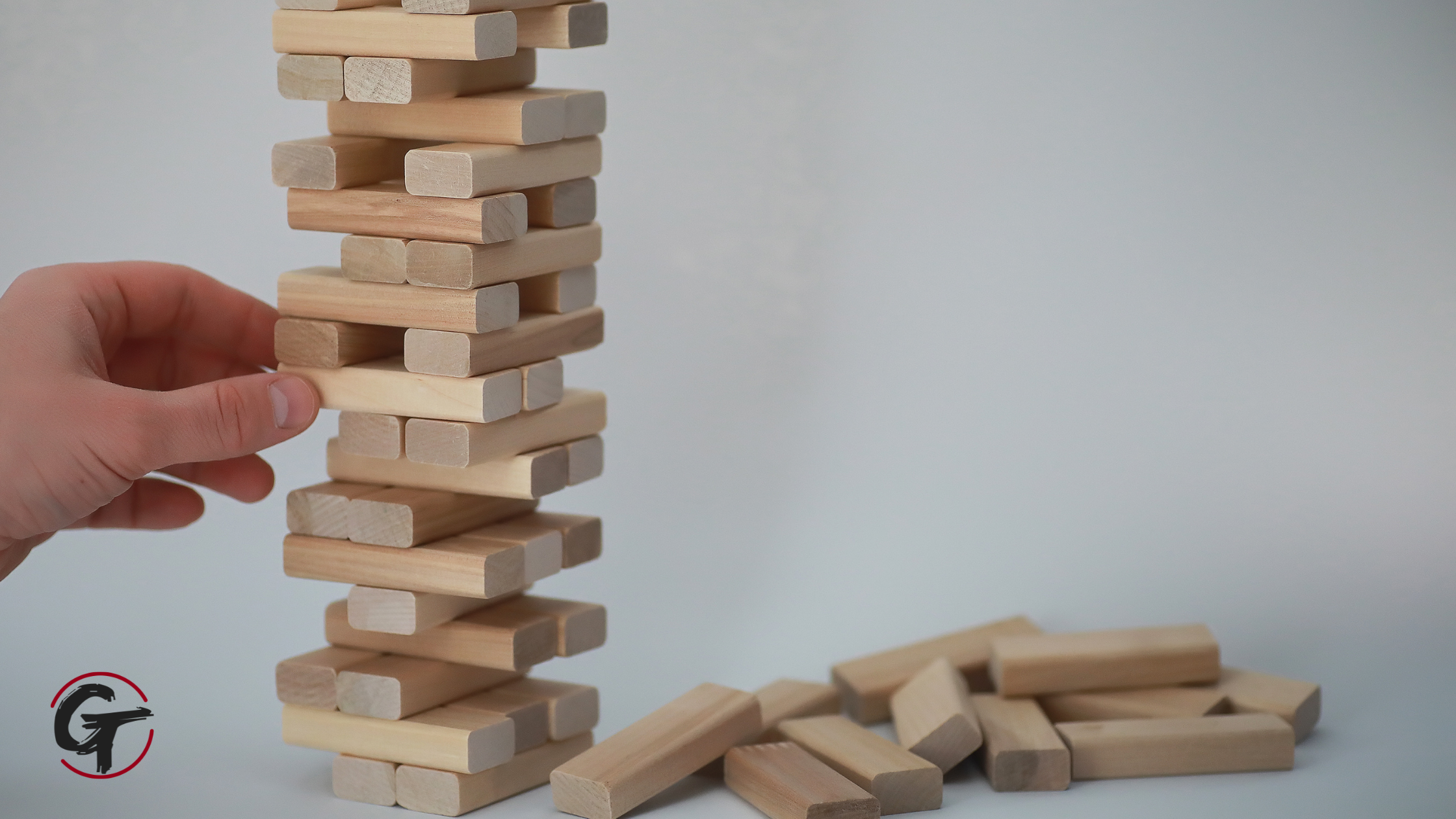 leadership-accountability-ripple-effect.jpg Hand removing a wooden block from a tower, illustrating how individual decisions can affect an entire team